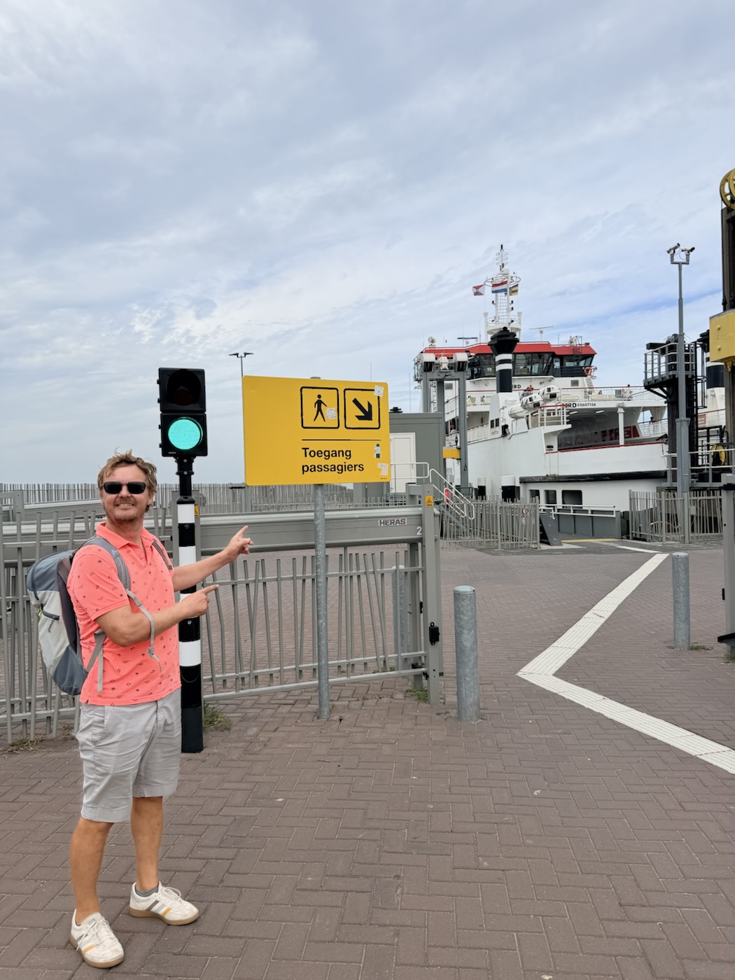 Addy wijst naar het bord 'Toegang passagiers' bij de veerboot
